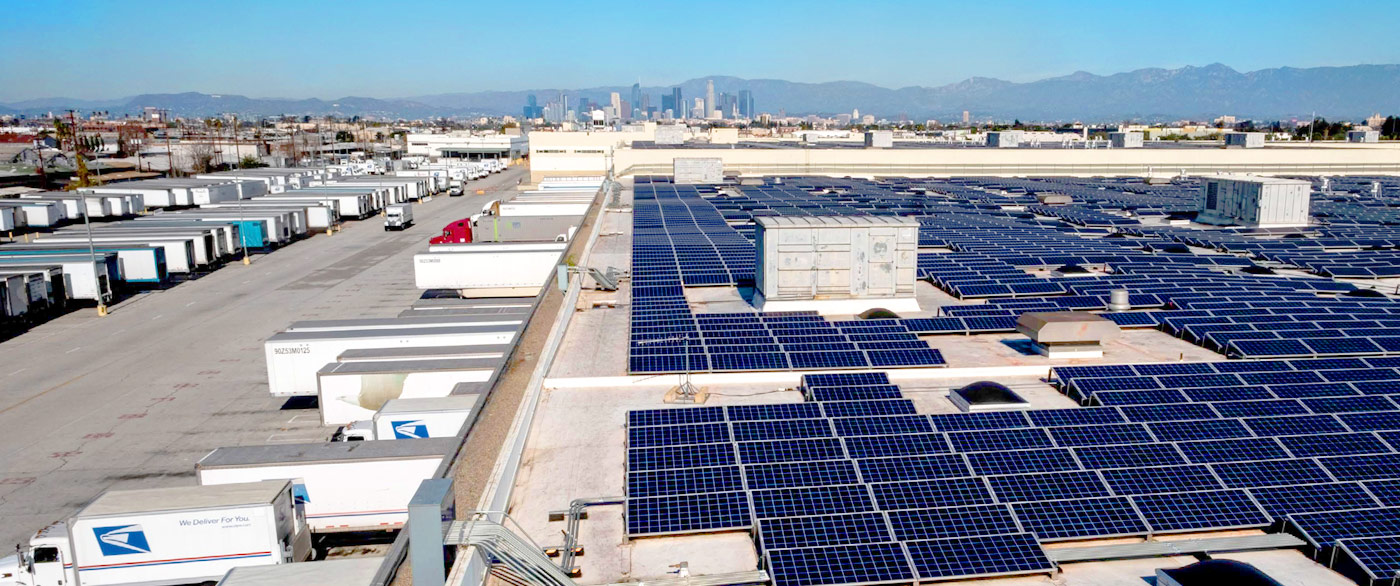 Aerial photo of a USPS facility rooftop in Los Angeles, equiped with solar panels.