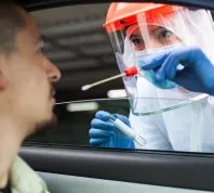 coronavirus test being administered to white man in car